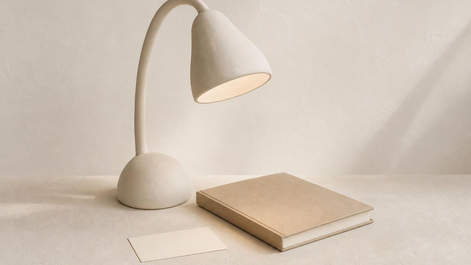 A simple clean desk with a single open notebook and a cup of tea